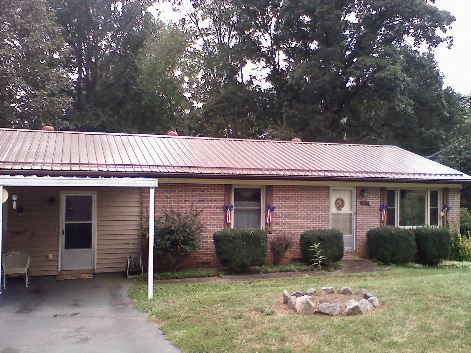 Bronze metal roof and carport on a brick ranch home — Roof Repair work by our crew in Warwick